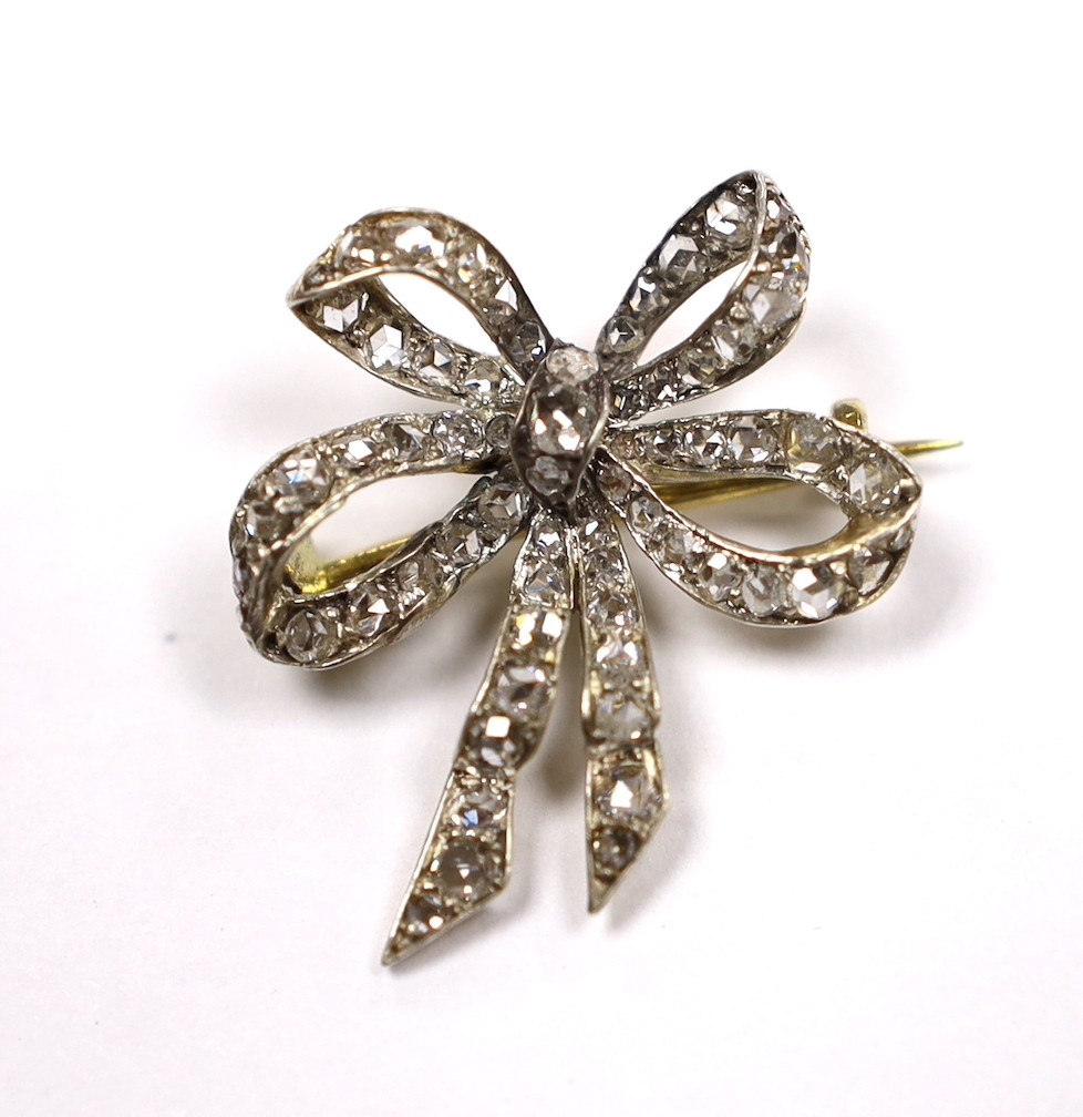 An early 20th century Austro-Hungarian yellow metal and diamond cluster set ribbon bow brooch, 26mm, gross weight 3.8 grams.